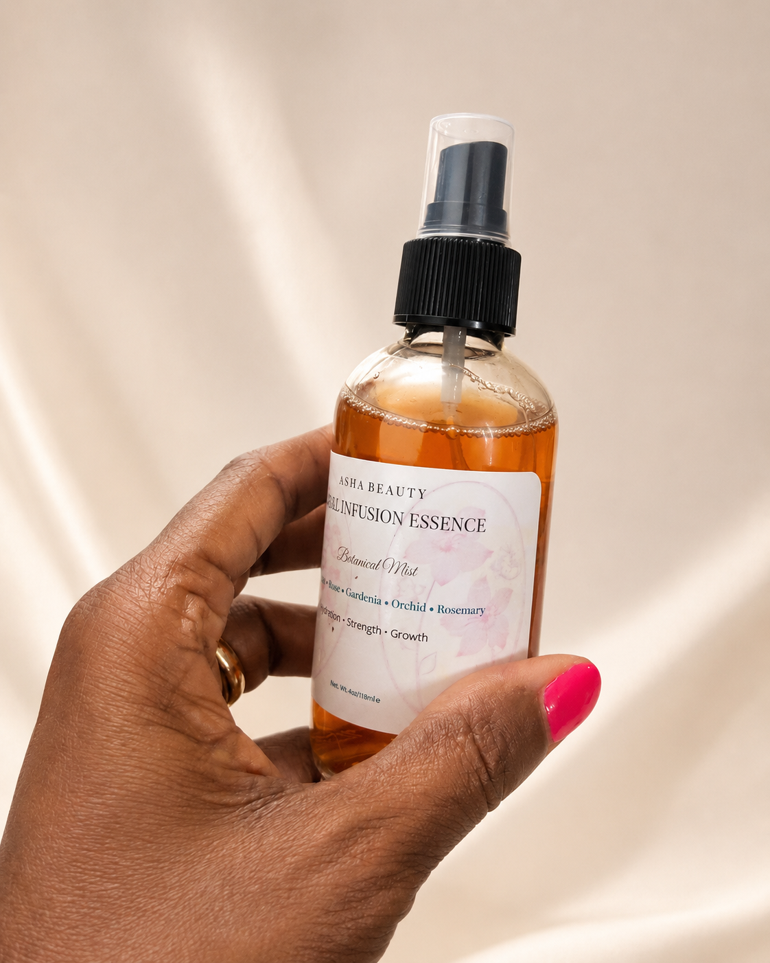 Hand holding Asha Belle Beauty Floral Infusion Botanical Mist spray bottle