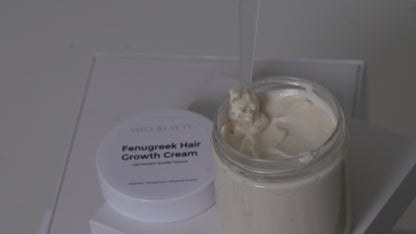 A jar of Asha Belle Beauty  Fenugreek Hair Growth Cream with its white lid beside it, showing a thick off-white cream inside a clear glass jar.
