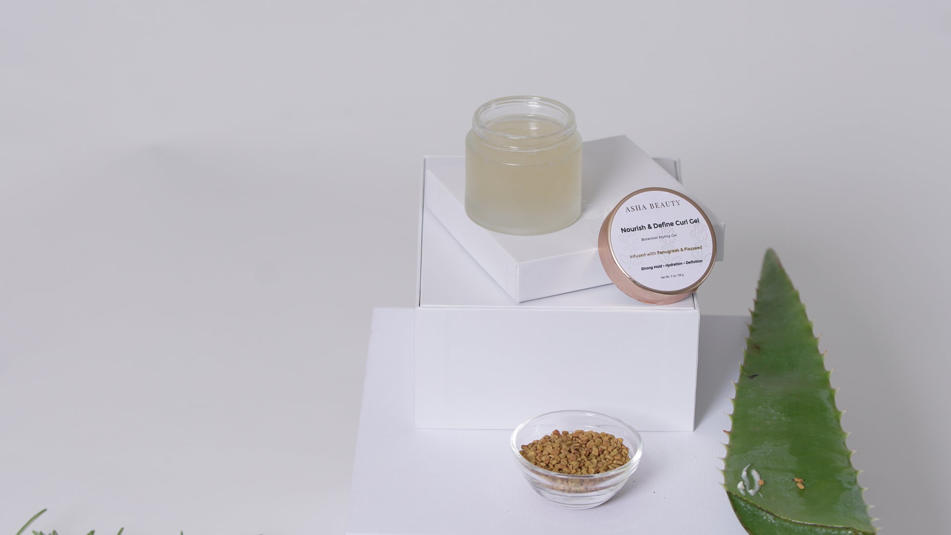 Asha Belle Beauty Nourish & Define Curl Gel styled with botanical ingredients on neutral background